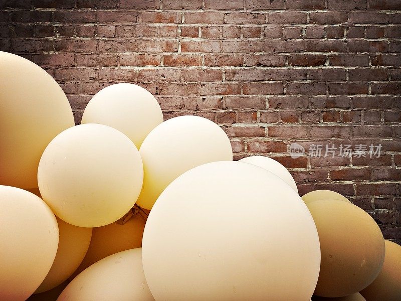 Brown and Blue Balloons against a Brick Wall